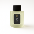 Light green bottle of 'Paradise' fragrance oil with black cap on a white background