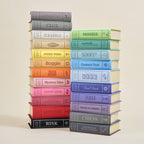 Stack of colorful board game boxes on a beige background