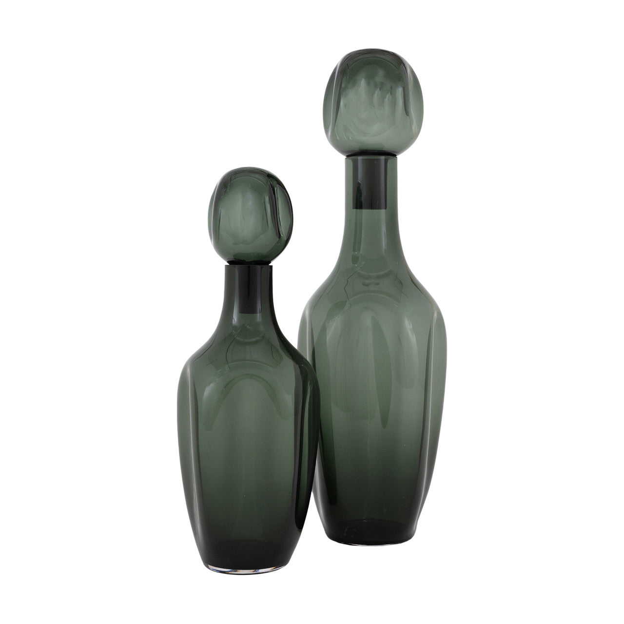 Two green glass bottles with unique shapes on a white background